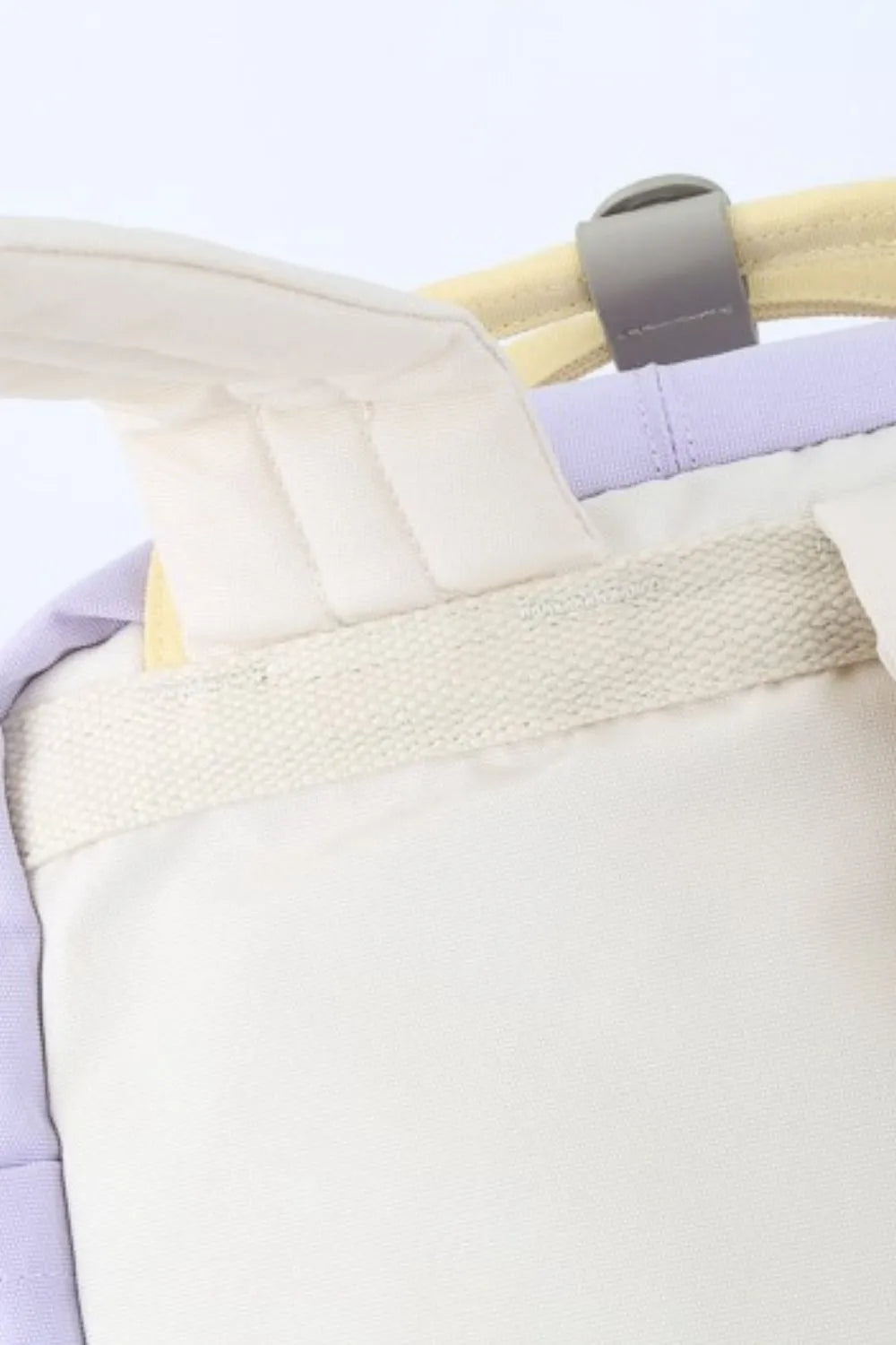 Purple water-resistant nylon backpack with white padded straps and contrast details.