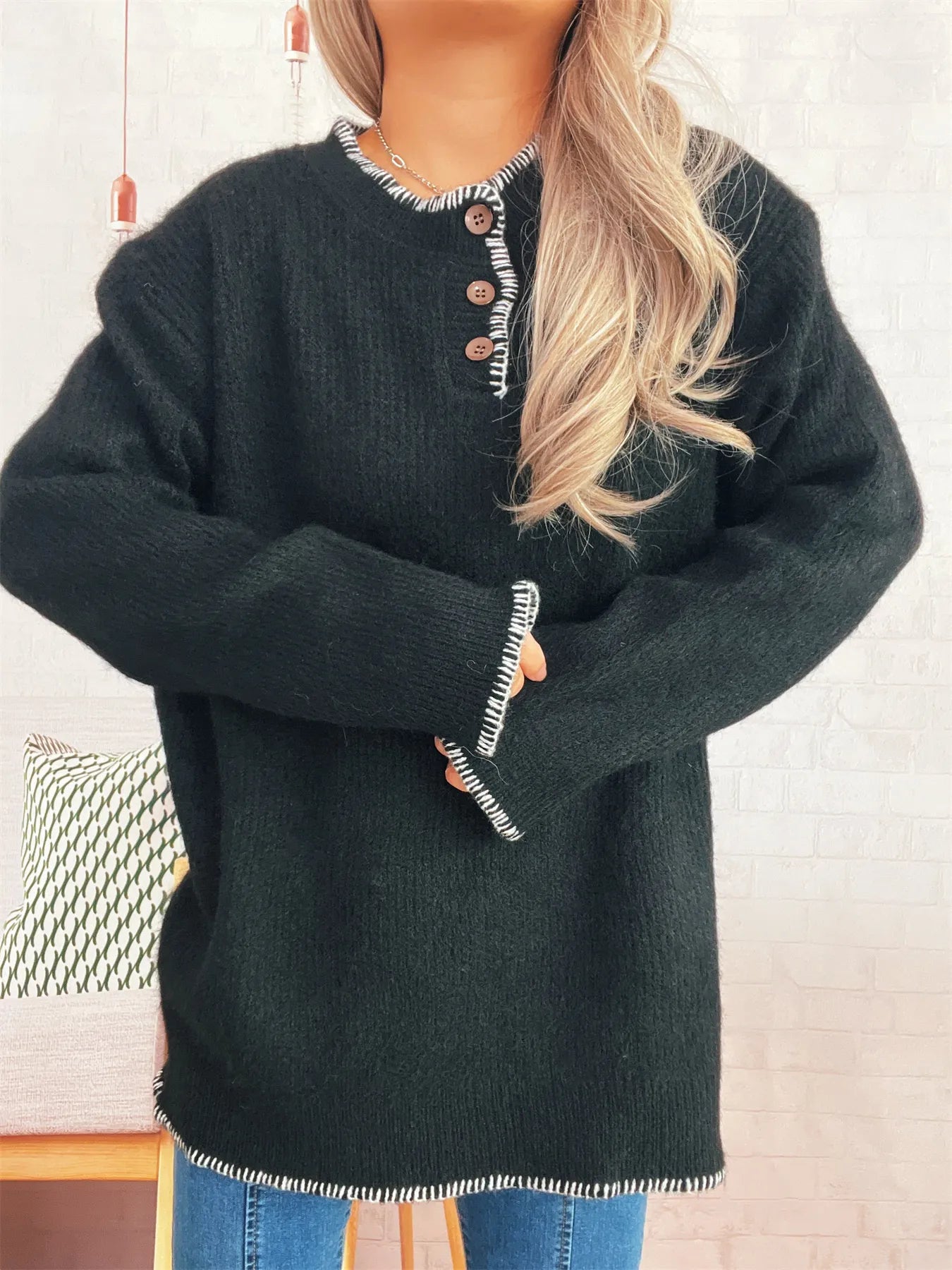 Oversized ribbed sweater with button details and contrast stitching in soft polyester.