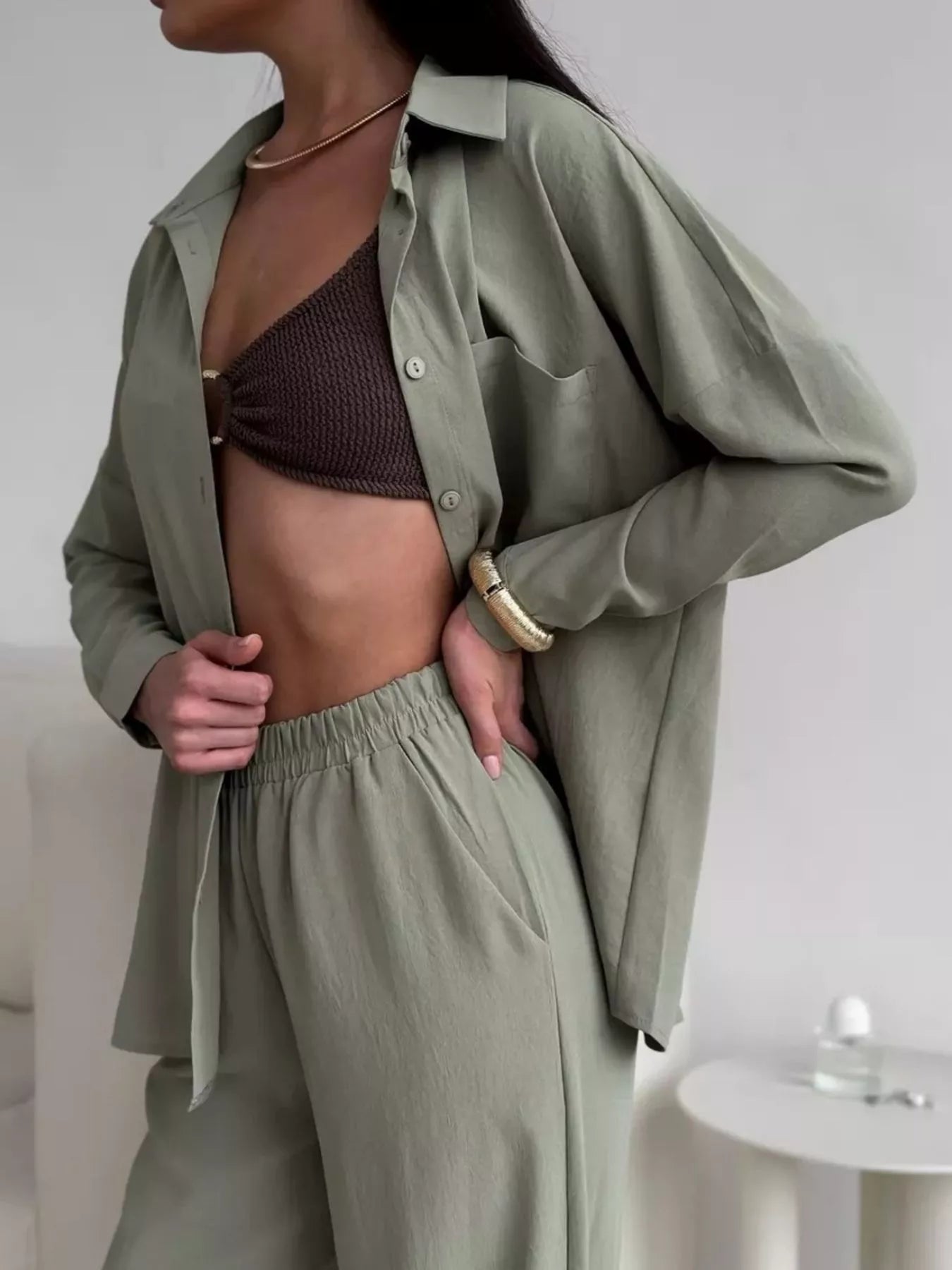 Woman wearing a green two-piece set with button-down shirt and elastic-waist pants.