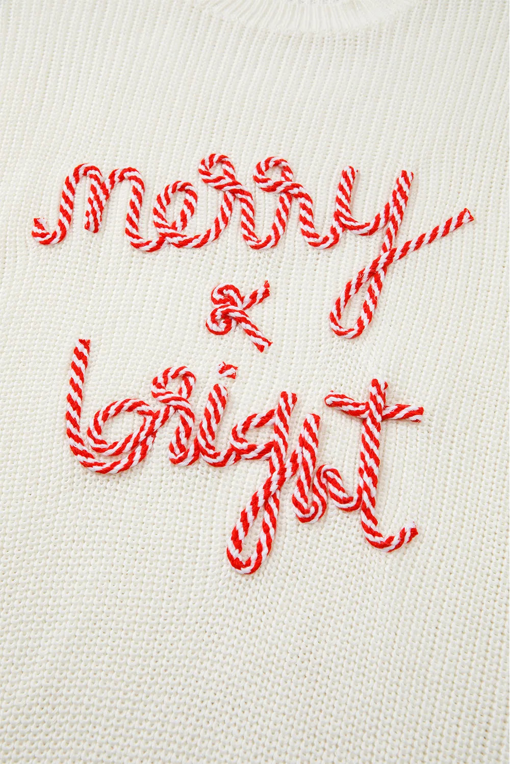 Cream round neck sweater with red embroidered "Merry & Bright" text.