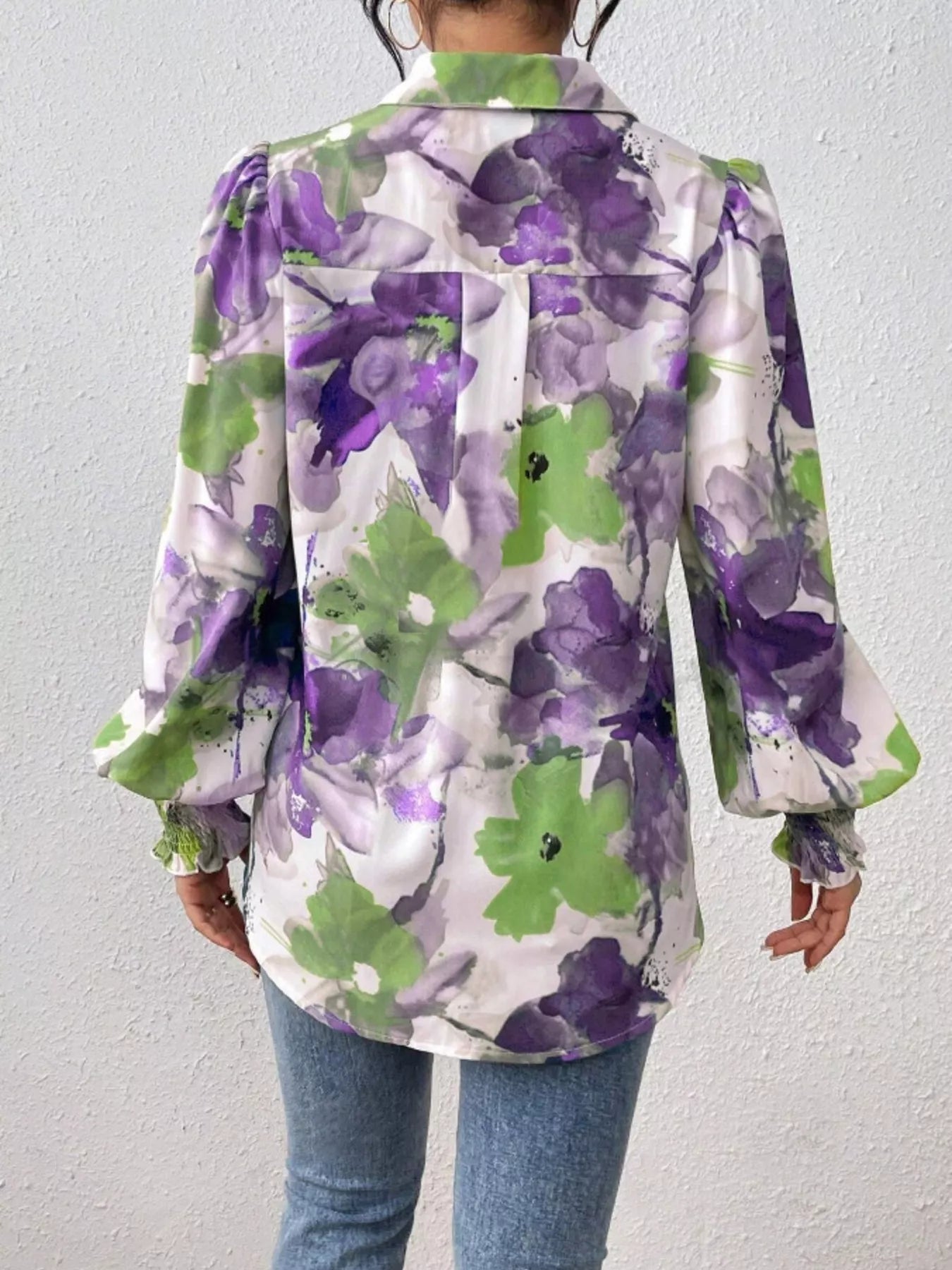 A printed button-up shirt with lantern sleeves made of a polyester blend.