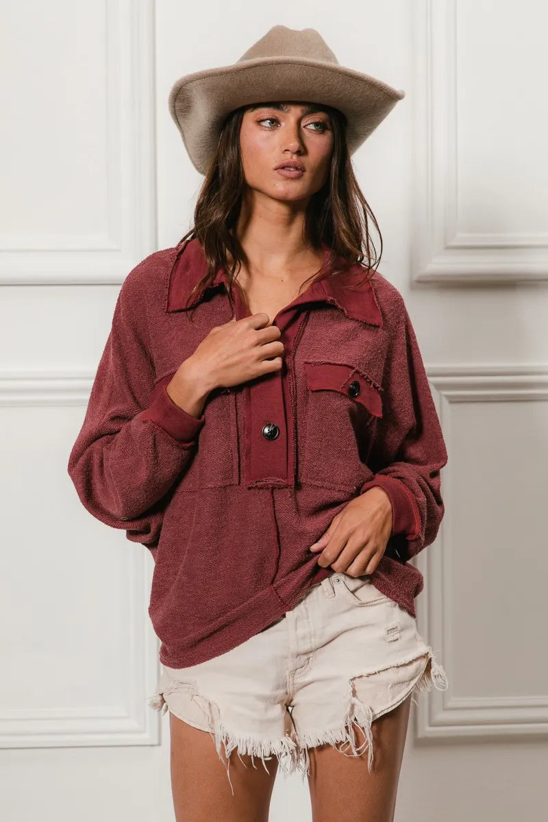 Oversized maroon French terry collared top with button and pocket details.