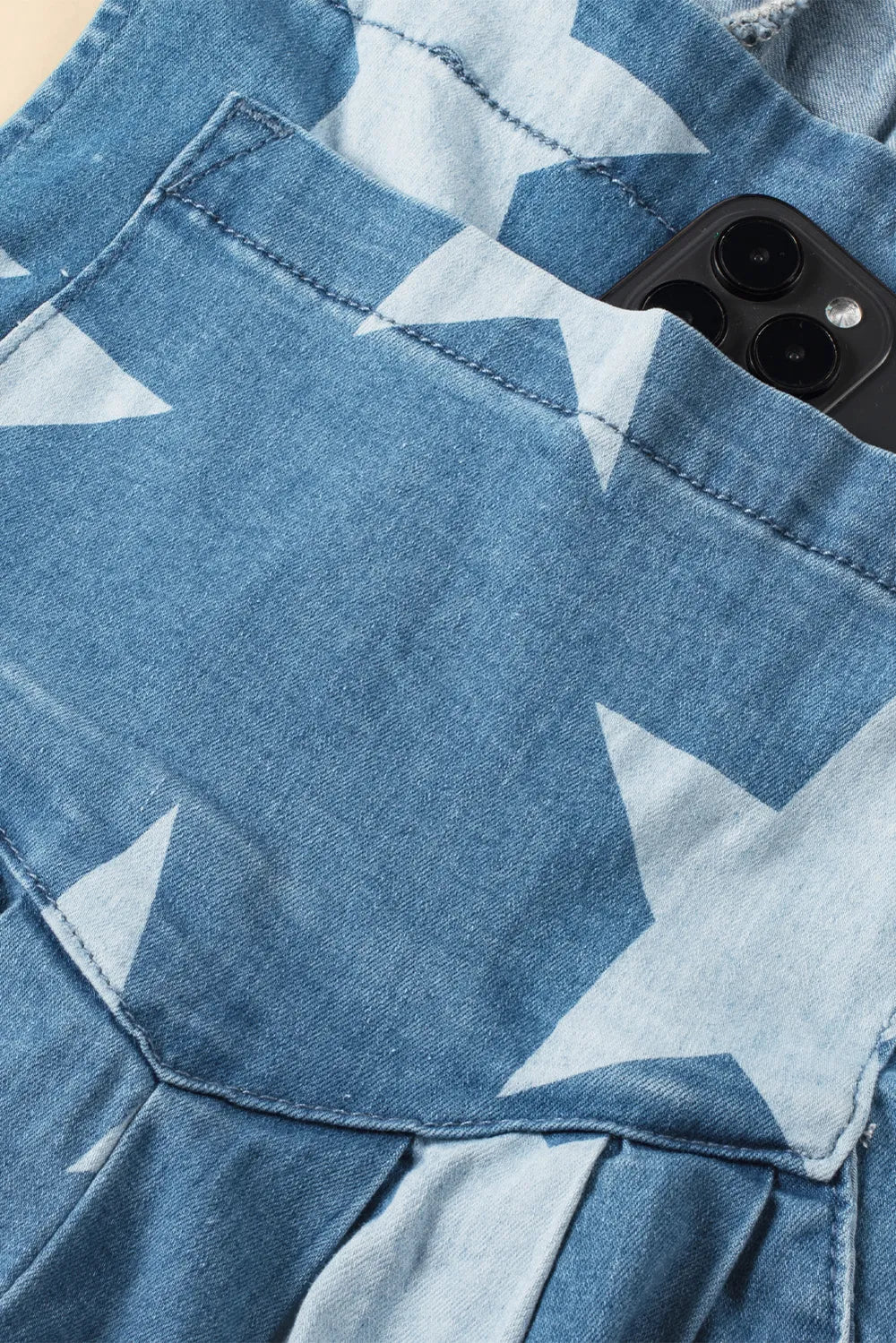 Wide leg denim overalls with star print, featuring pockets and a cotton blend fabric.