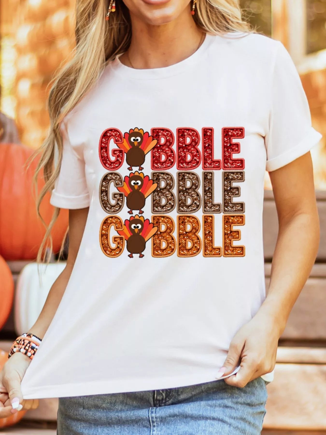 White poly-cotton T-shirt with multicolored "Gobble" text and turkey graphics for Thanksgiving.