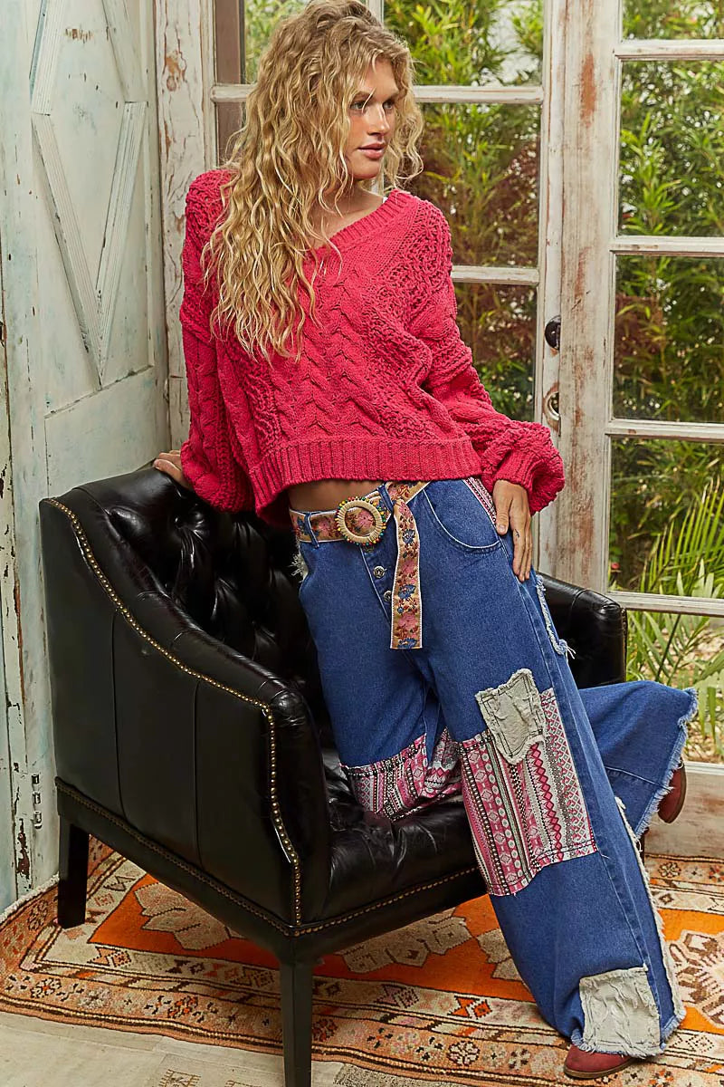 Red cable-knit V-neck cropped sweater with balloon sleeves on model.