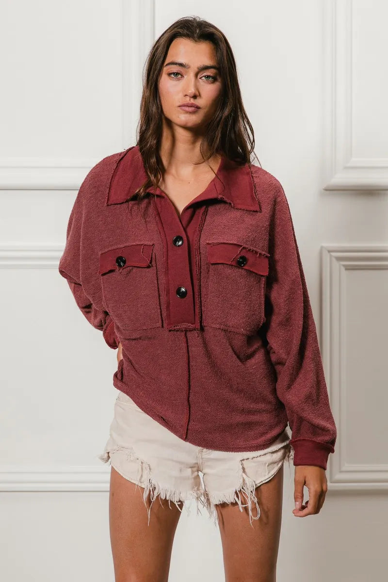Oversized maroon French terry collared top with buttons and pockets, modeled on a woman.