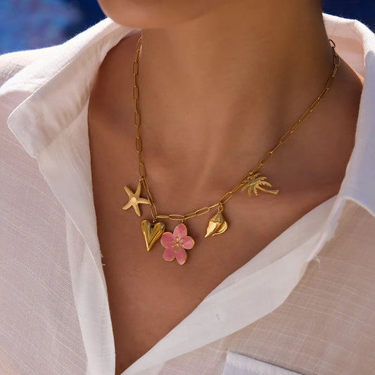 Gold-toned necklace with pink resin flower, starfish, heart, shell, and palm charms.
