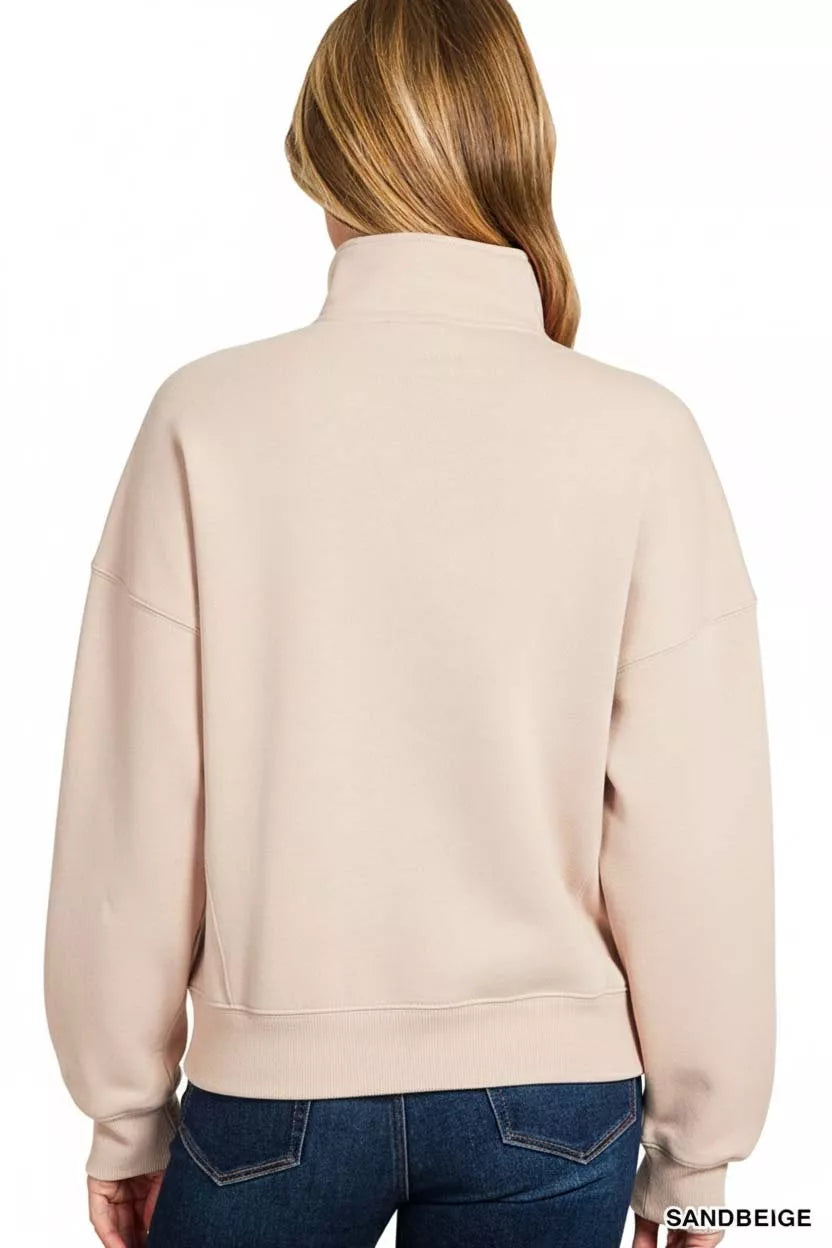 Sand beige half-zip sweatshirt with high neck, long sleeves, ribbed cuffs, and relaxed fit.