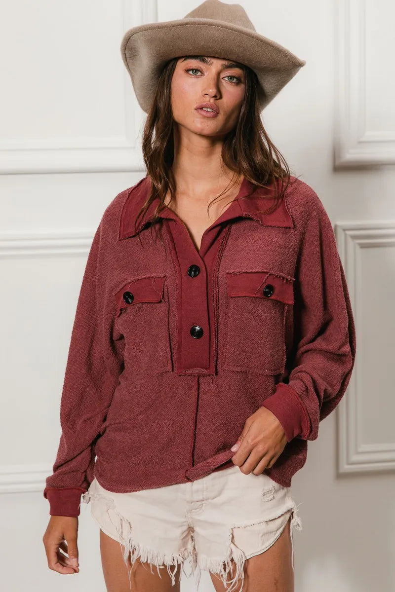 Oversized maroon French terry collared top with buttons and pockets, modeled on a woman.