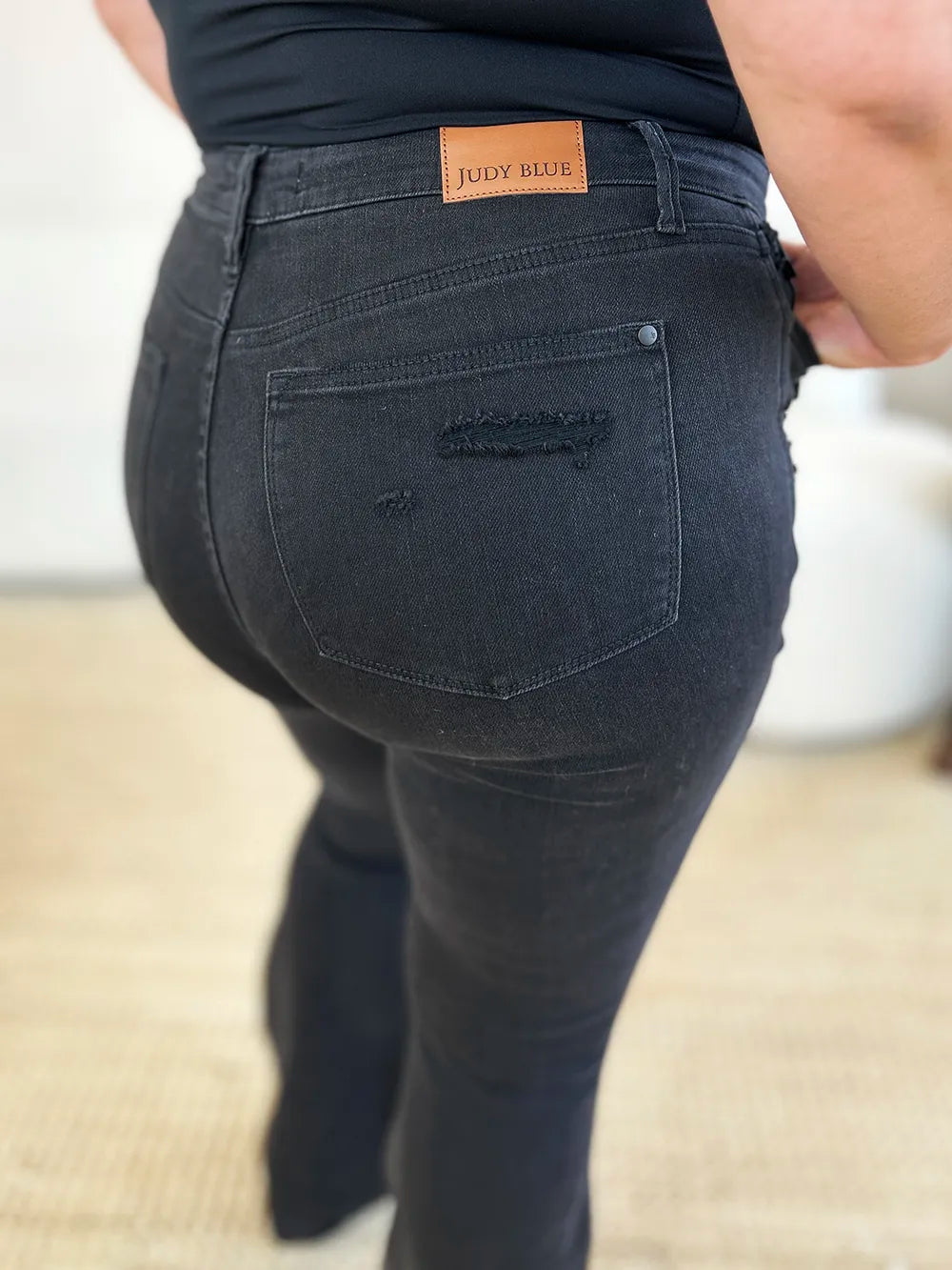 Rear view of Judy Blue high-waist distressed flare jeans on a model.