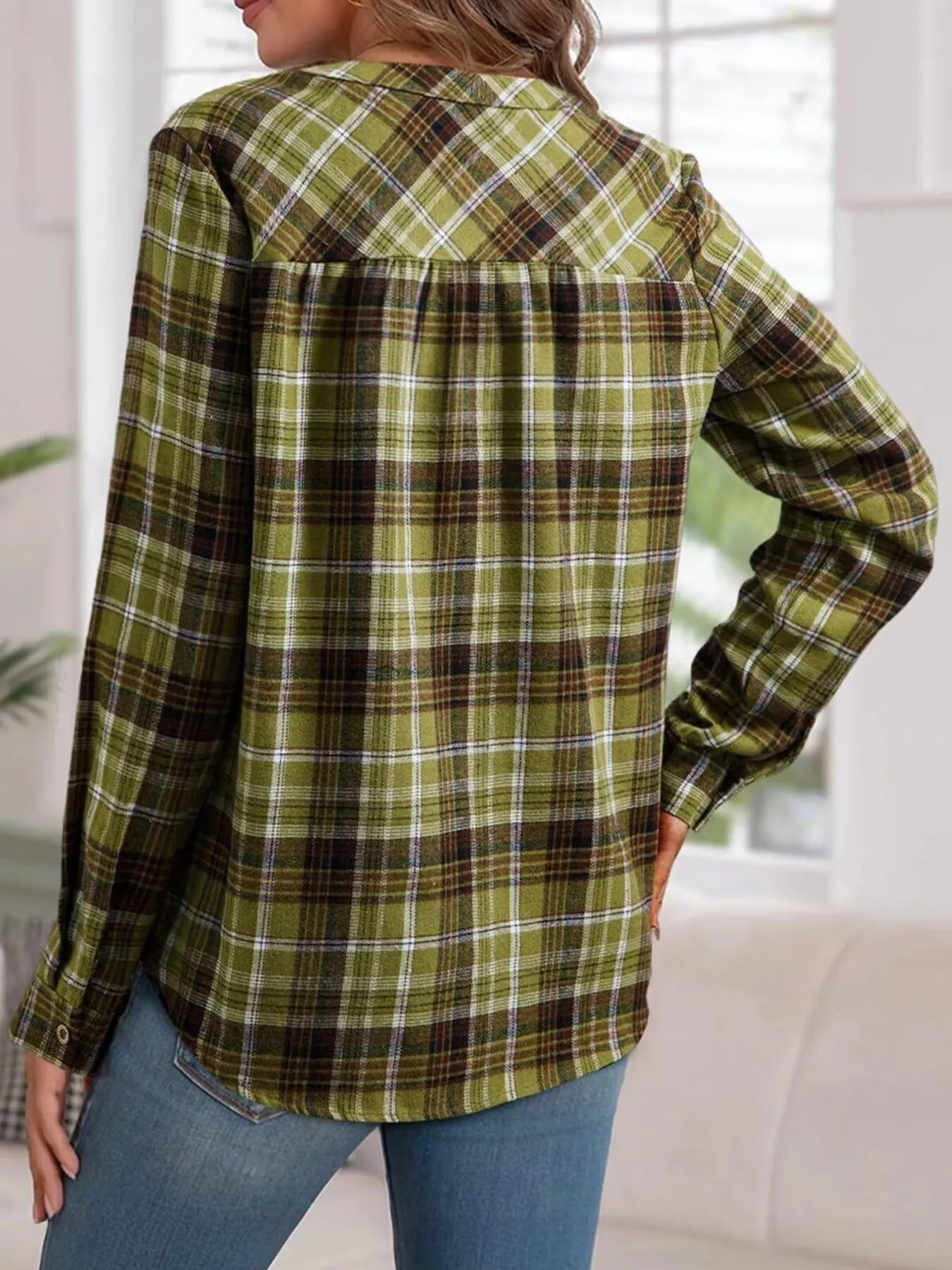 Plaid long sleeve blouse with half button front, made of polyester and spandex blend.