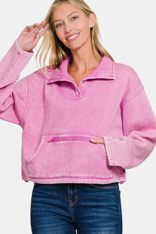Woman modeling a pink acid wash fleece half snap sweatshirt with kangaroo pocket.
