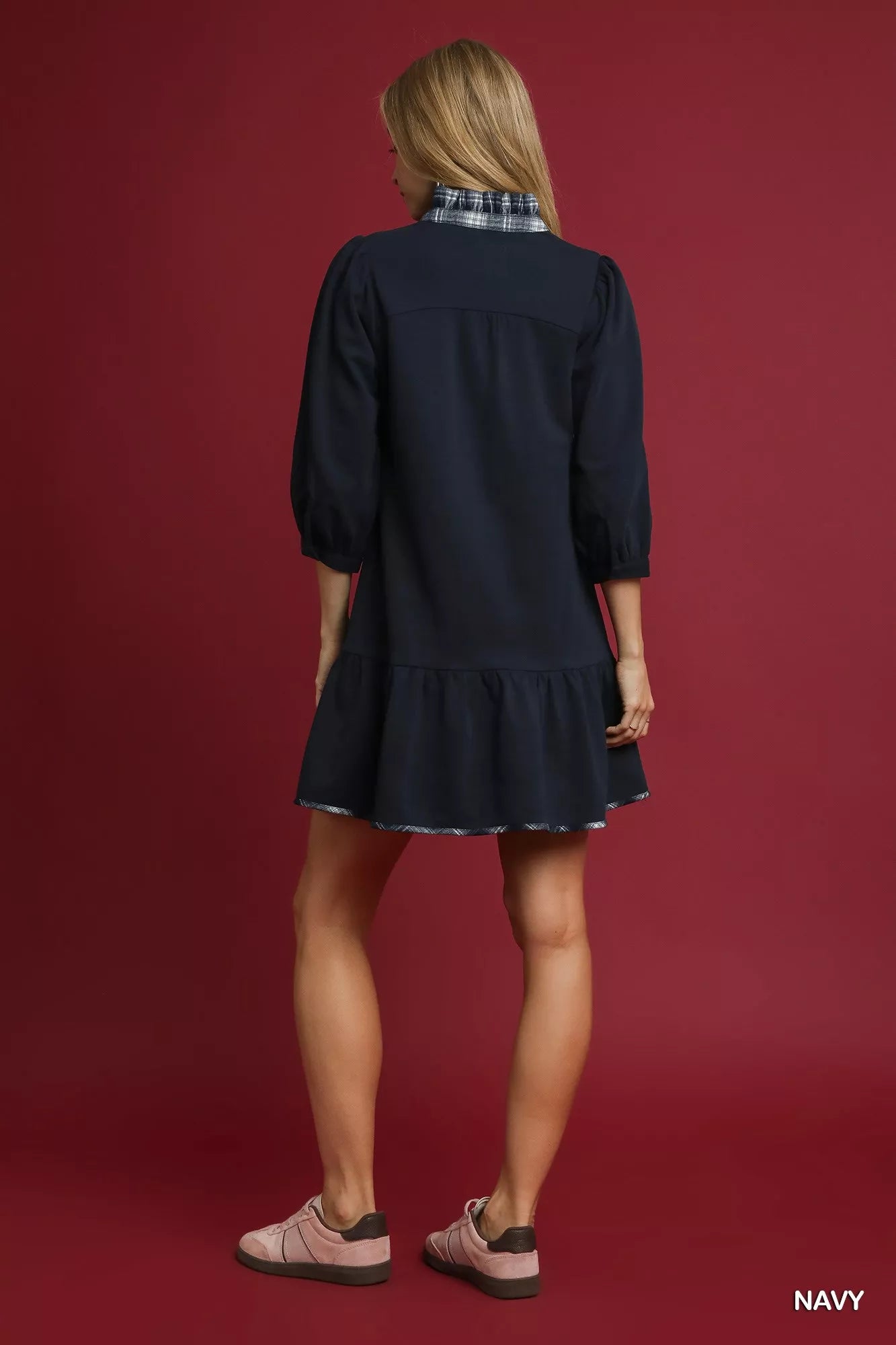 Rear view of navy French terry ruffle hem dress with plaid collar trim.