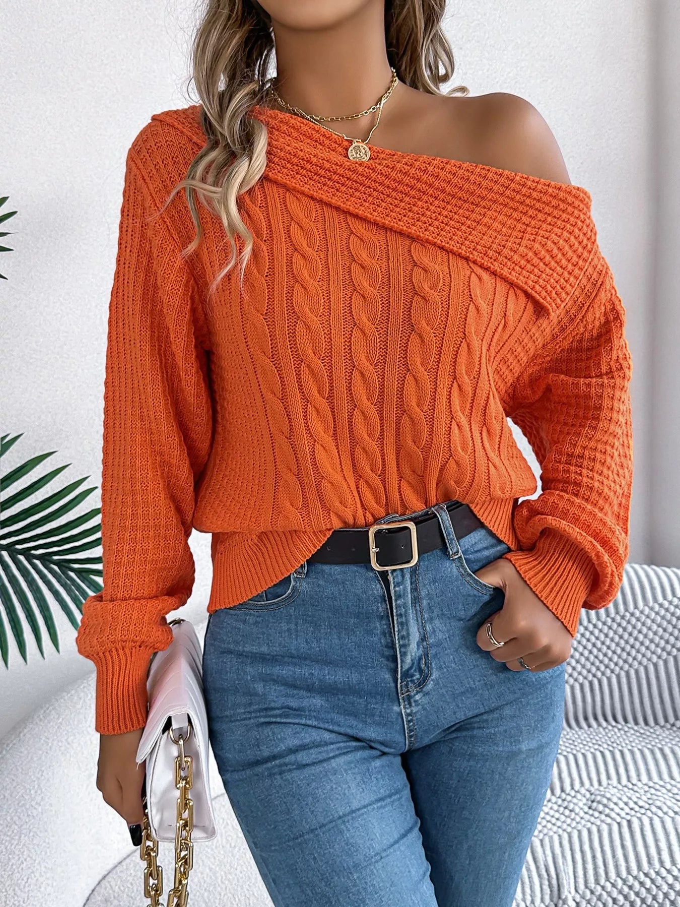 Light gray cable knit off-shoulder sweater made of slightly stretchy acrylic fabric.