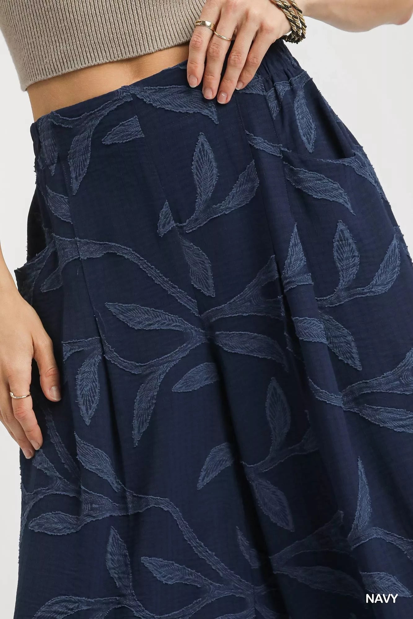 Navy jacquard wide-leg pants with leaf pattern, pockets, and flowy silhouette.