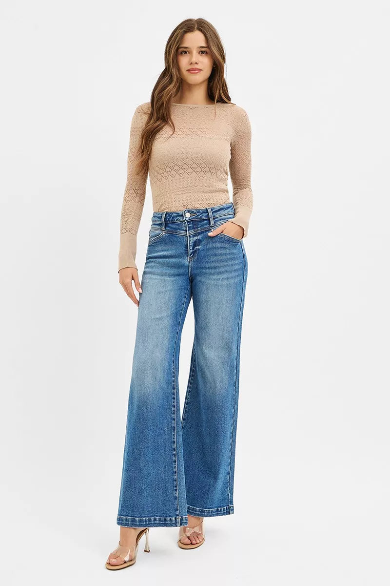 Woman modeling high-rise wide-leg jeans with heart-shaped back pockets and front yoke.