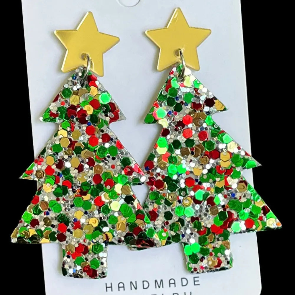 Pair of festive acrylic Christmas tree dangle earrings with gold star accents on a white card.