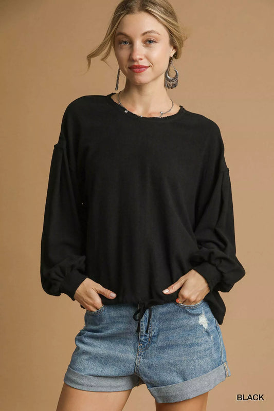 Woman modeling plus size black linen long sleeve drawstring top with puffed sleeves.