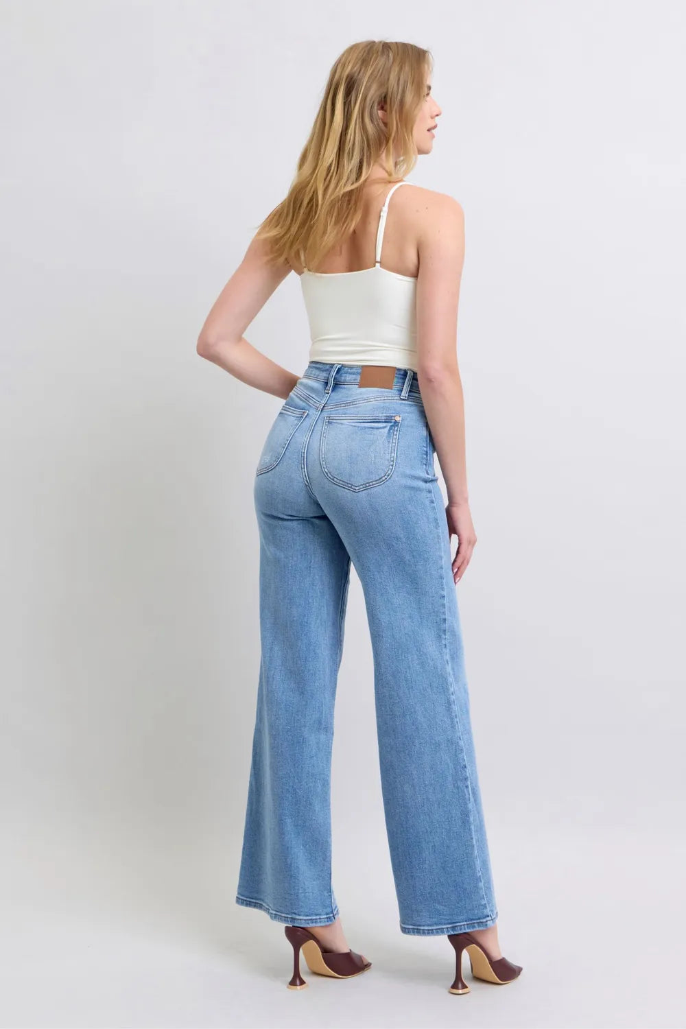 Rear view of Judy Blue high-waist wide-leg jeans with pockets, modeled on a woman.