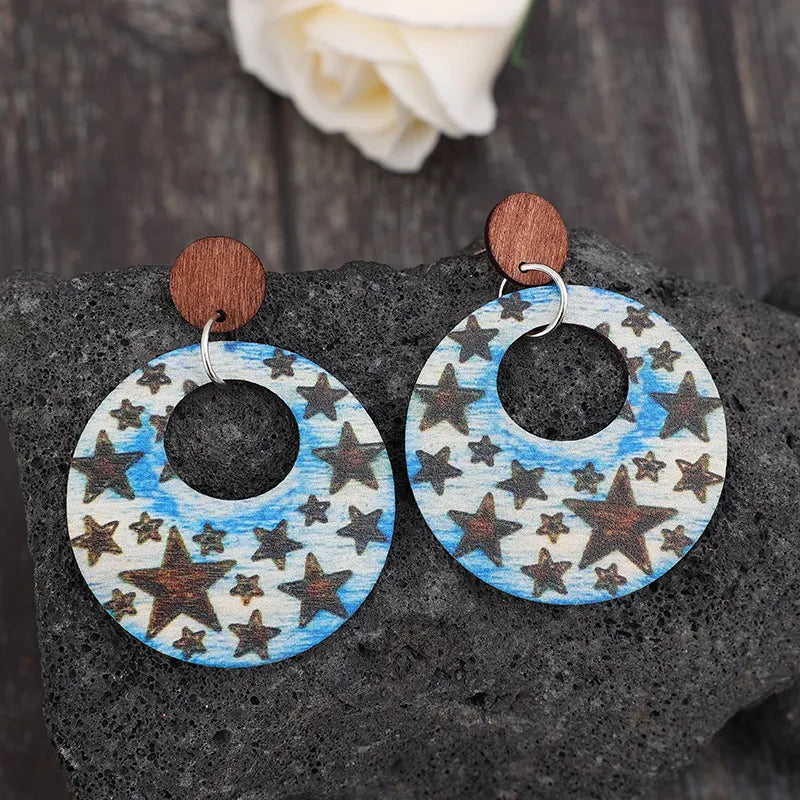 Wooden dangle earrings with cutout star design made of alloy and wood, 2.6 inches long
