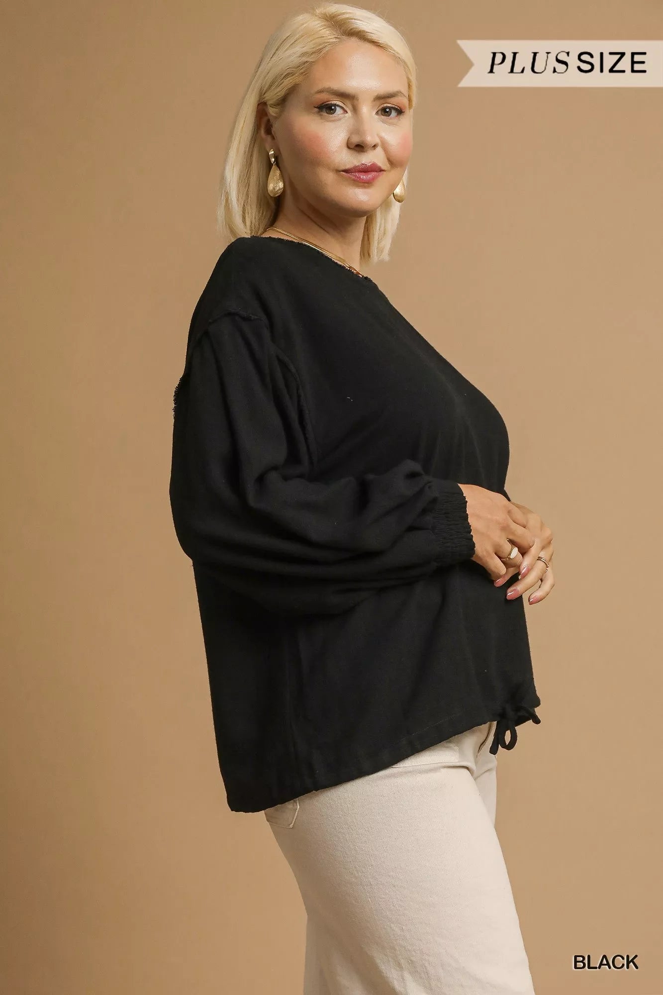 Plus size black linen long sleeve drawstring top on model.