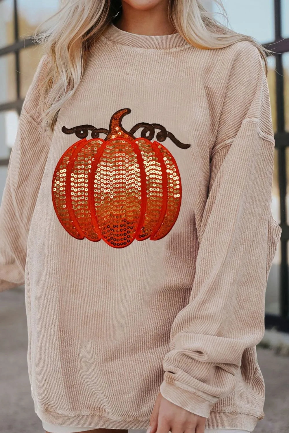 Long sleeve round neck sweatshirt featuring a sequin pumpkin design on a cozy fabric.