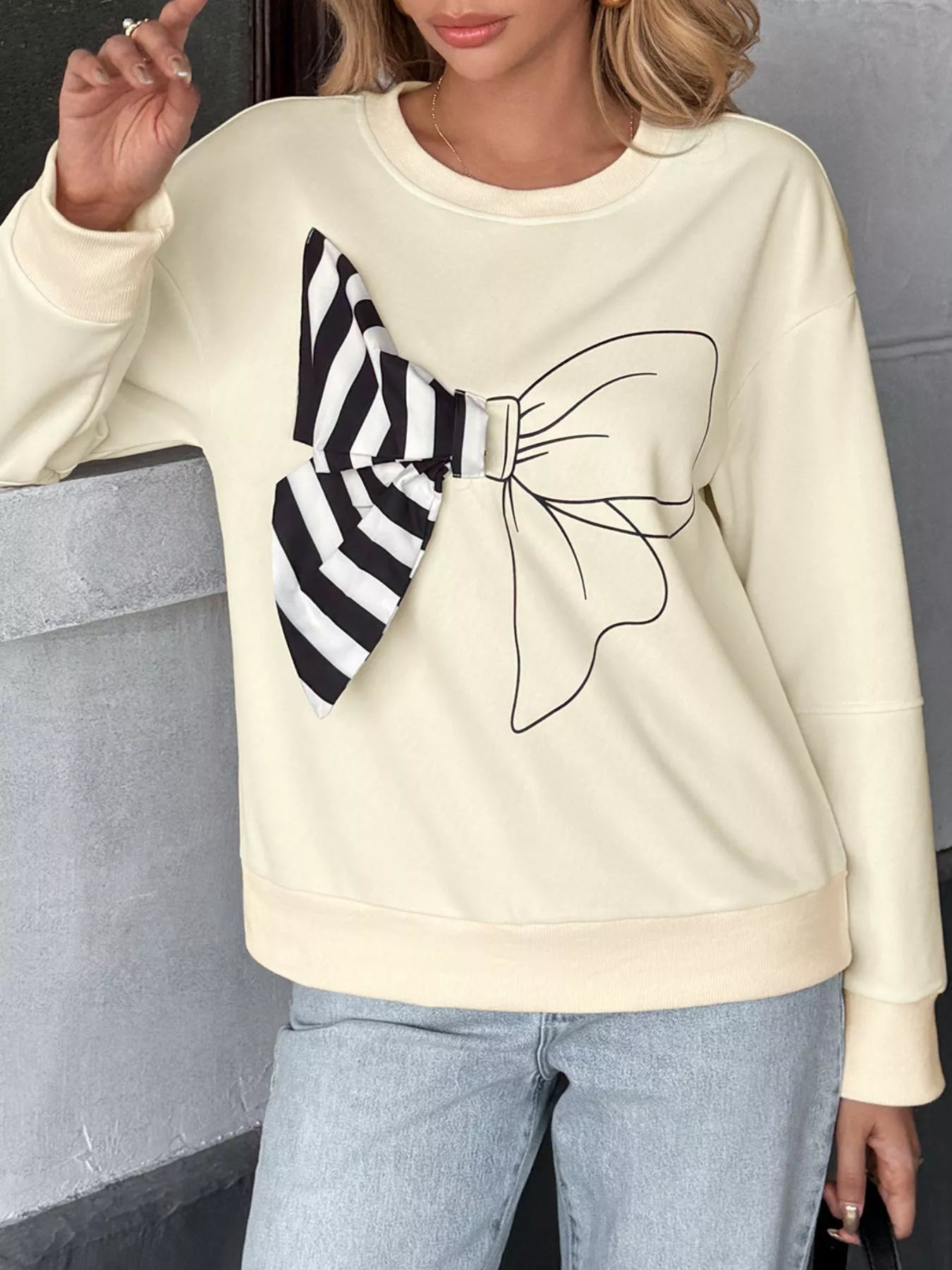 Round neck sweatshirt with dropped shoulders and bow detail in polyester blend fabric