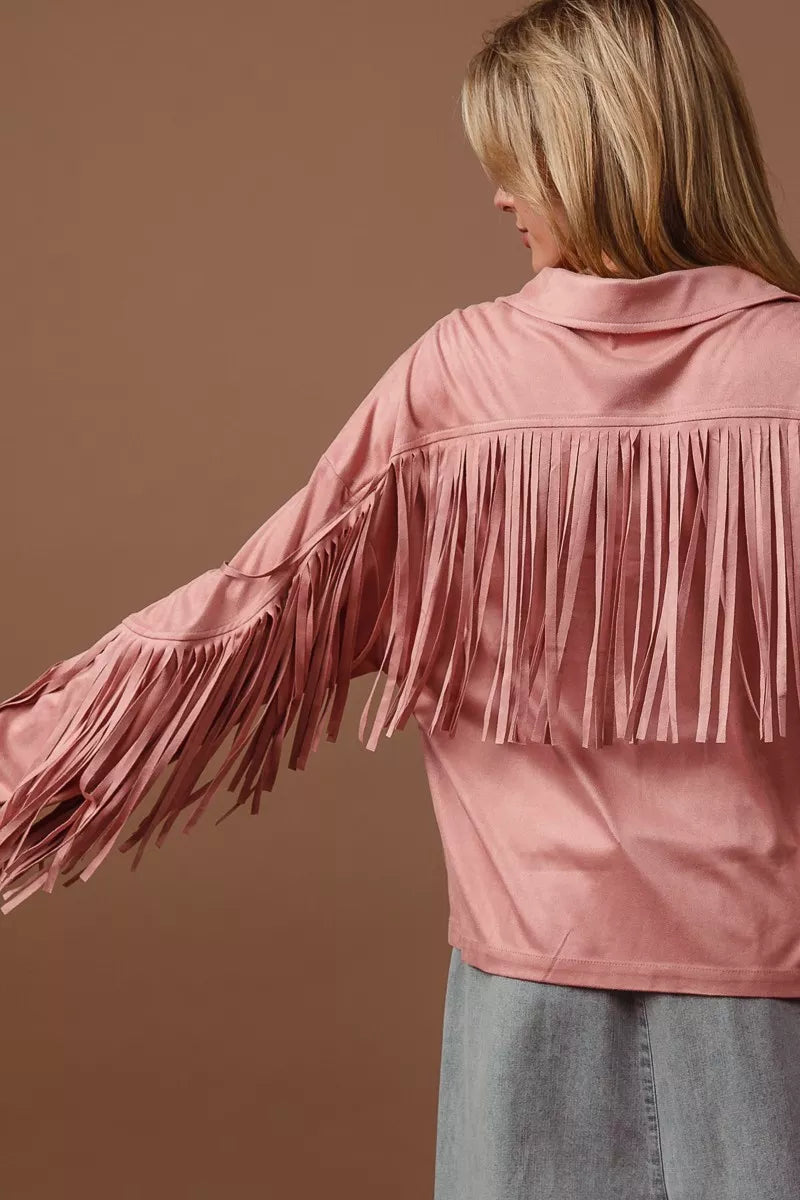 Back view of a pink suede fringe long sleeve jacket on a model.