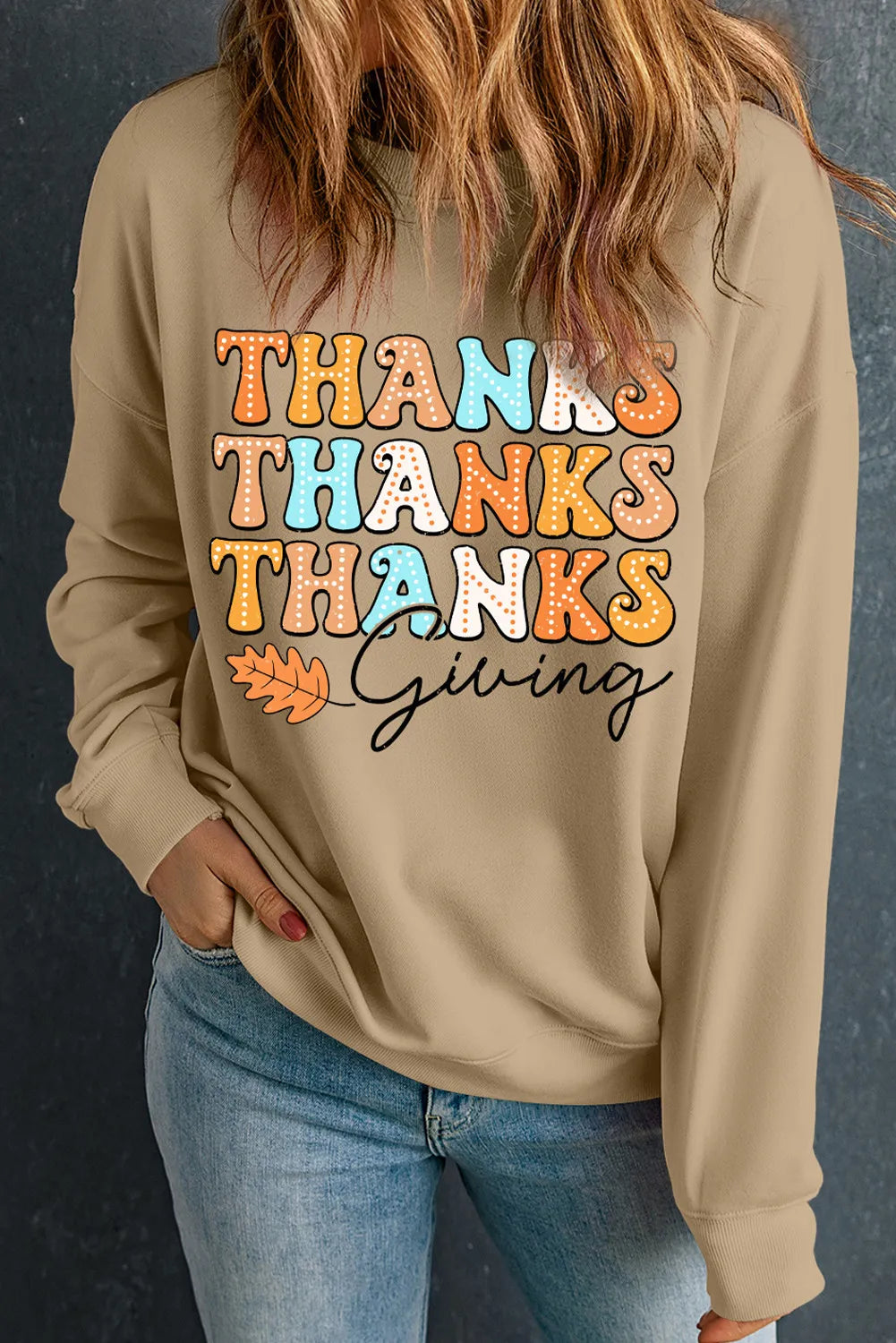 Beige dropped shoulder sweatshirt with colorful "Thanks Thanks Thanks Giving" text and leaf graphic.