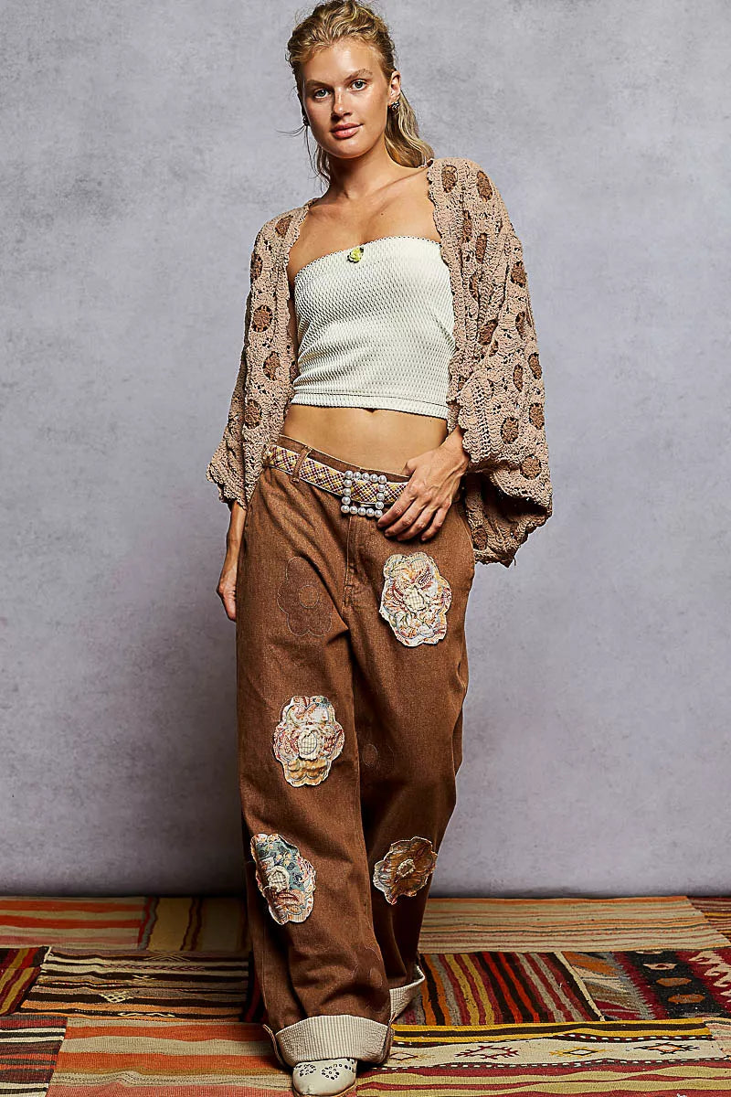 Woman modeling a beige openwork V-neck chenille cardigan with floral contrast.