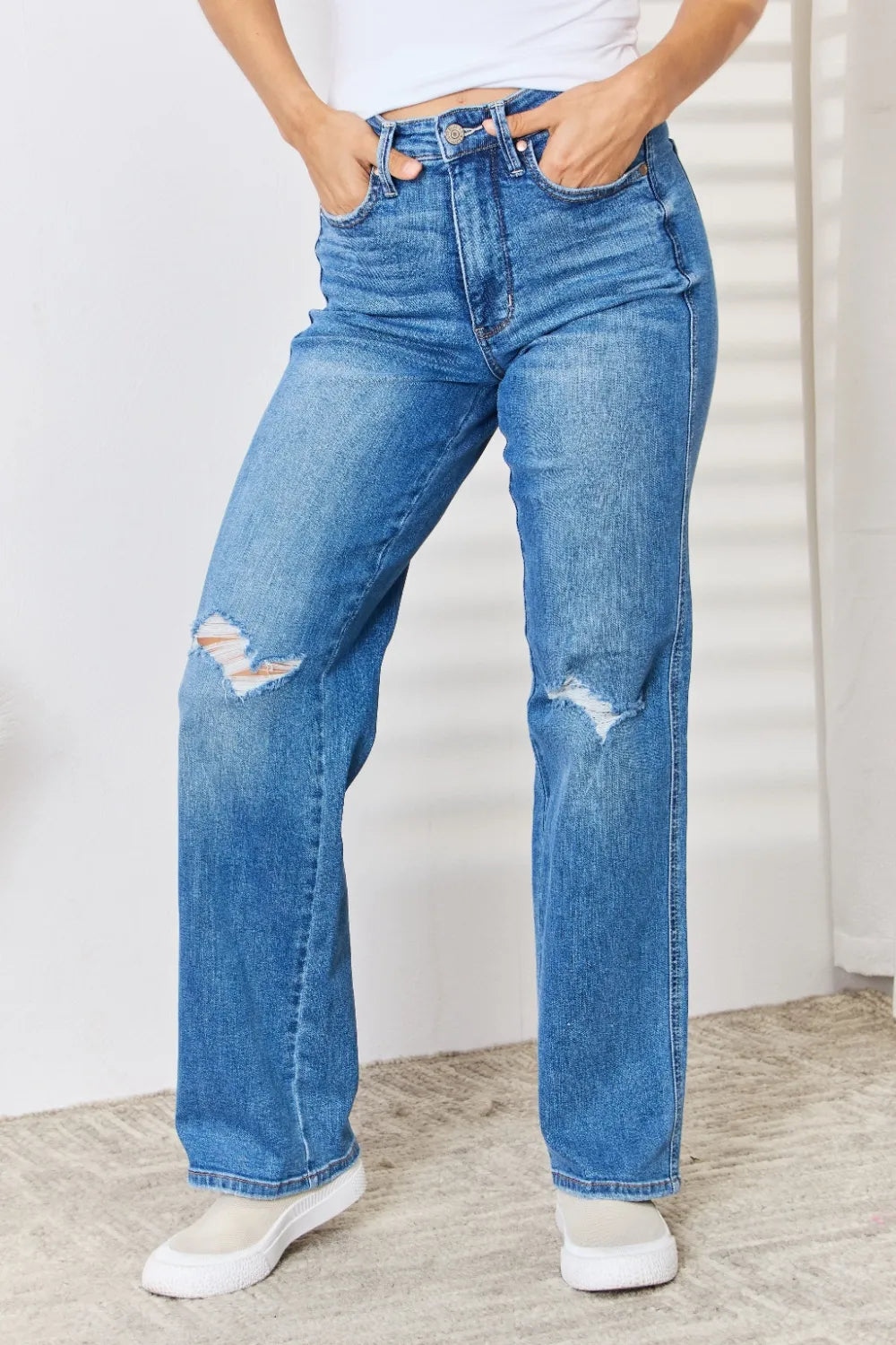 Woman modeling Judy Blue high-waist distressed straight-leg jeans in light wash.