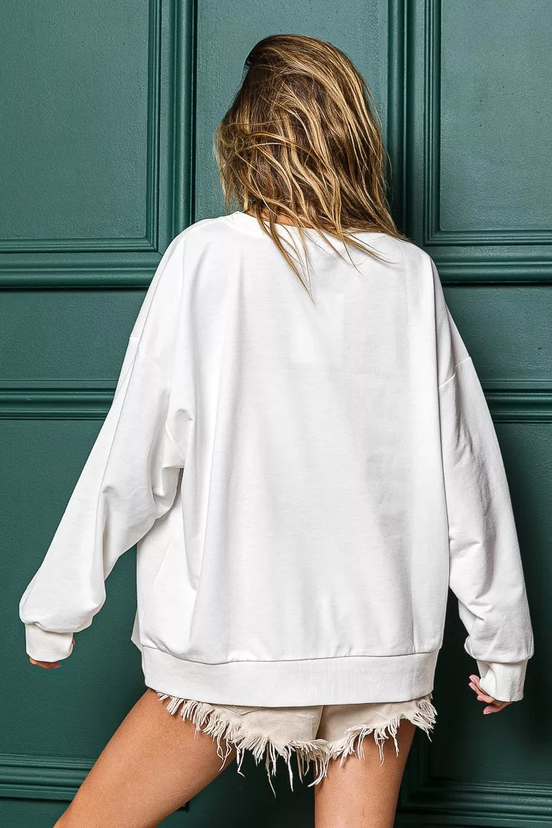 Back view of a woman wearing a white oversized French terry sweatshirt with "Holly Jolly Christmas" graphic.