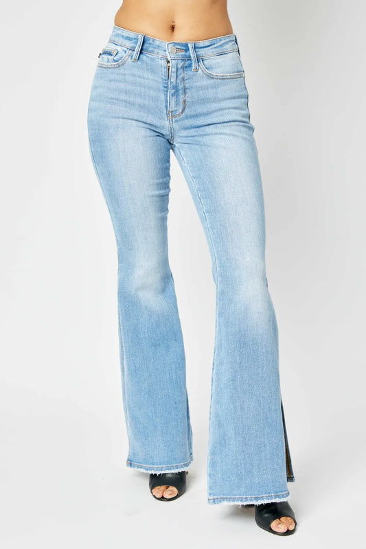 Light wash mid-rise flare jeans with raw hem on a model.