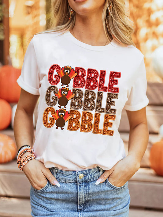 White poly-cotton T-shirt with multicolored "Gobble" text and turkey graphics for Thanksgiving.