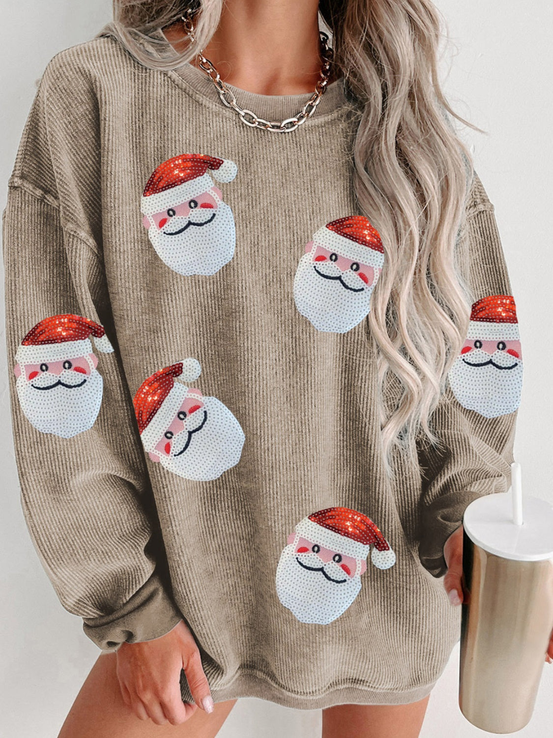 Beige ribbed sweatshirt with sequin Santa patches and long sleeves.