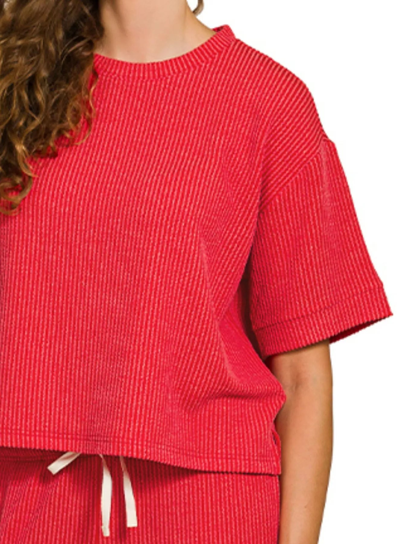 Woman wearing red raised rib short sleeve tee and drawstring pants set.