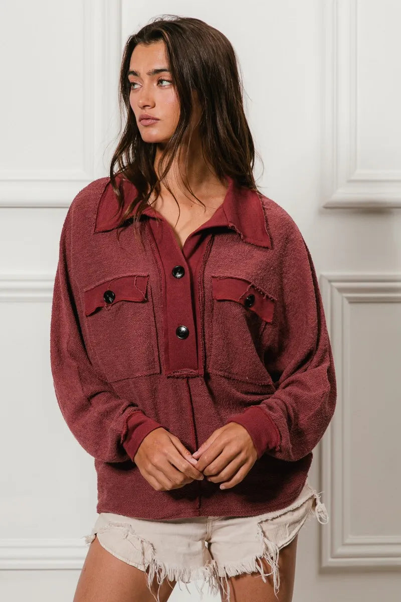 Oversized maroon French terry collared top with buttons and pockets, modeled on a woman.