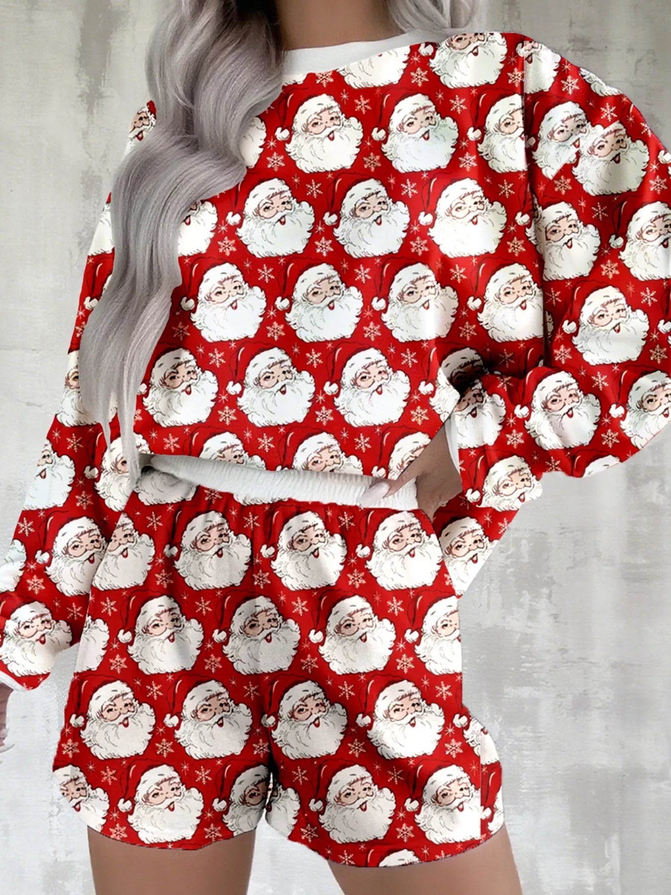 Pink lounge set with festive Santa print, featuring a long-sleeve top and shorts.