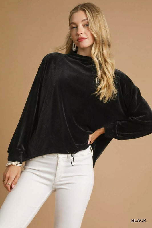 Oversized black ribbed knit top with drawstring hem on a model.