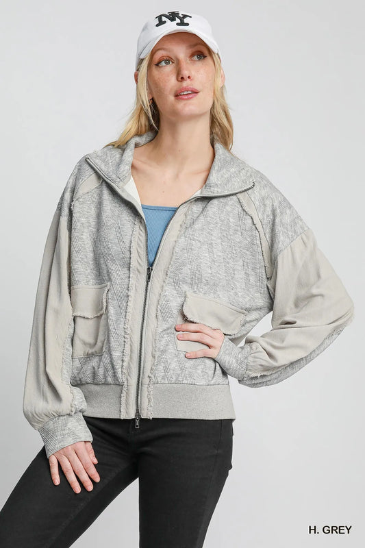 Woman modeling gray two-way jacquard zip-up linen jacket with hood and pockets.
