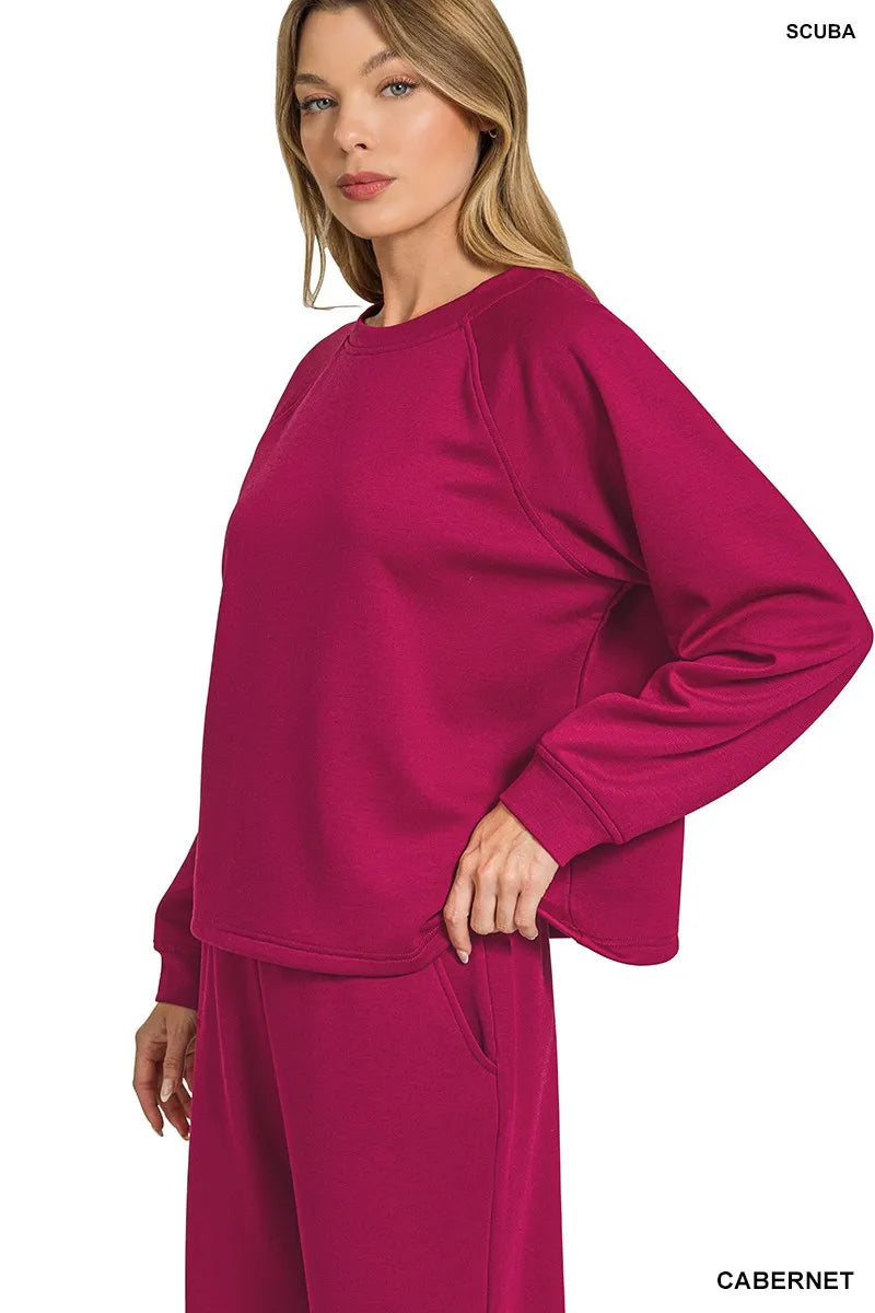 Model posing in Zenana Cabernet scuba crewneck sweatshirt and wide-leg pants set.