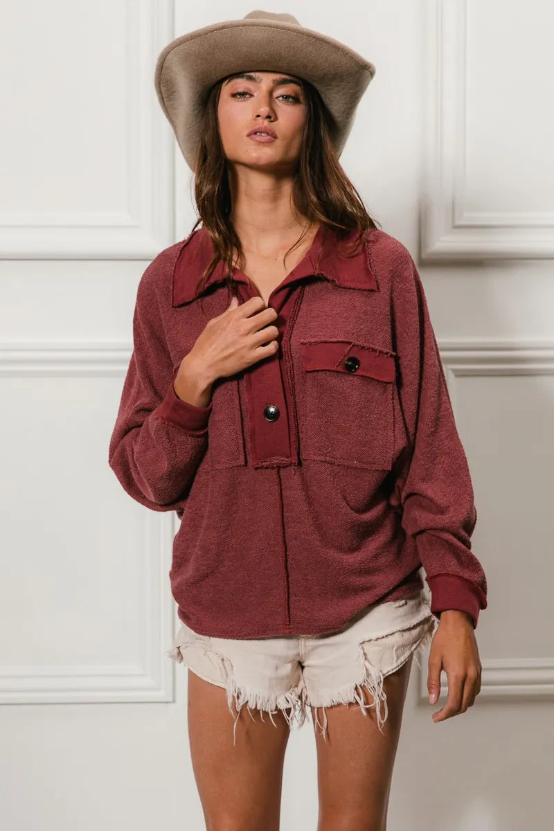 Oversized maroon French terry collared top with buttons and pockets, model wearing with hat and shorts.