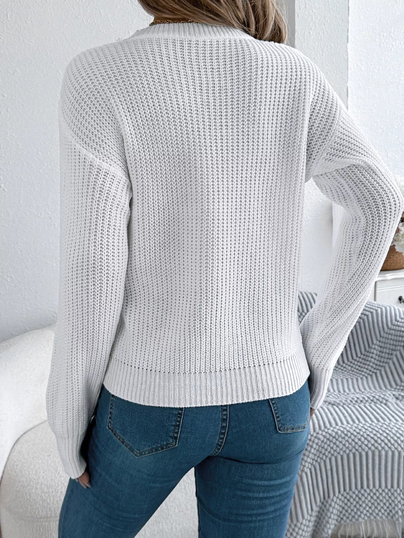 Lightweight acrylic sweater with openwork knit, round neck, and slightly stretchy fit.