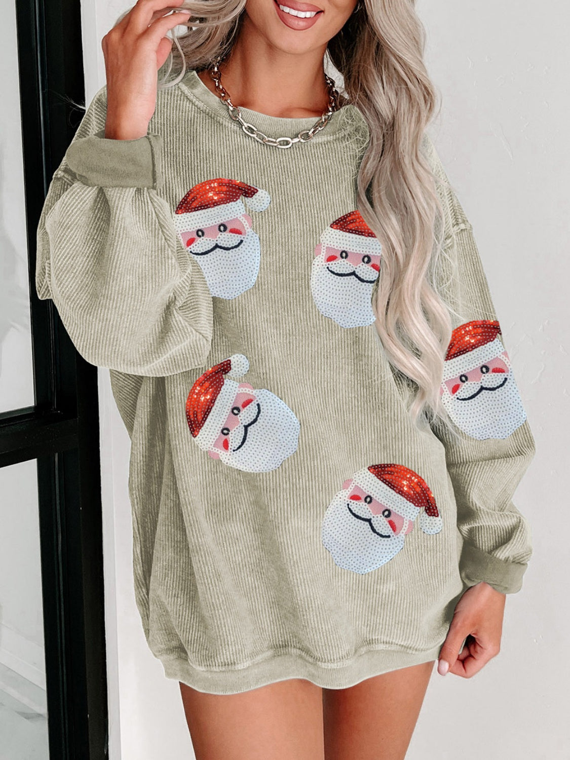 Cream ribbed sweatshirt with sequin Santa patches and long sleeves.