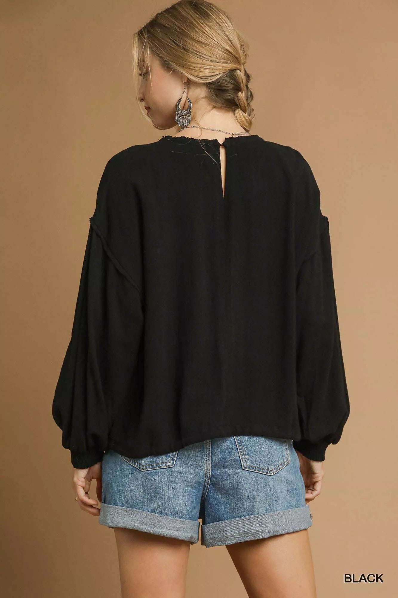 Black plus-size linen long-sleeve top with drawstring detail, modeled from back.