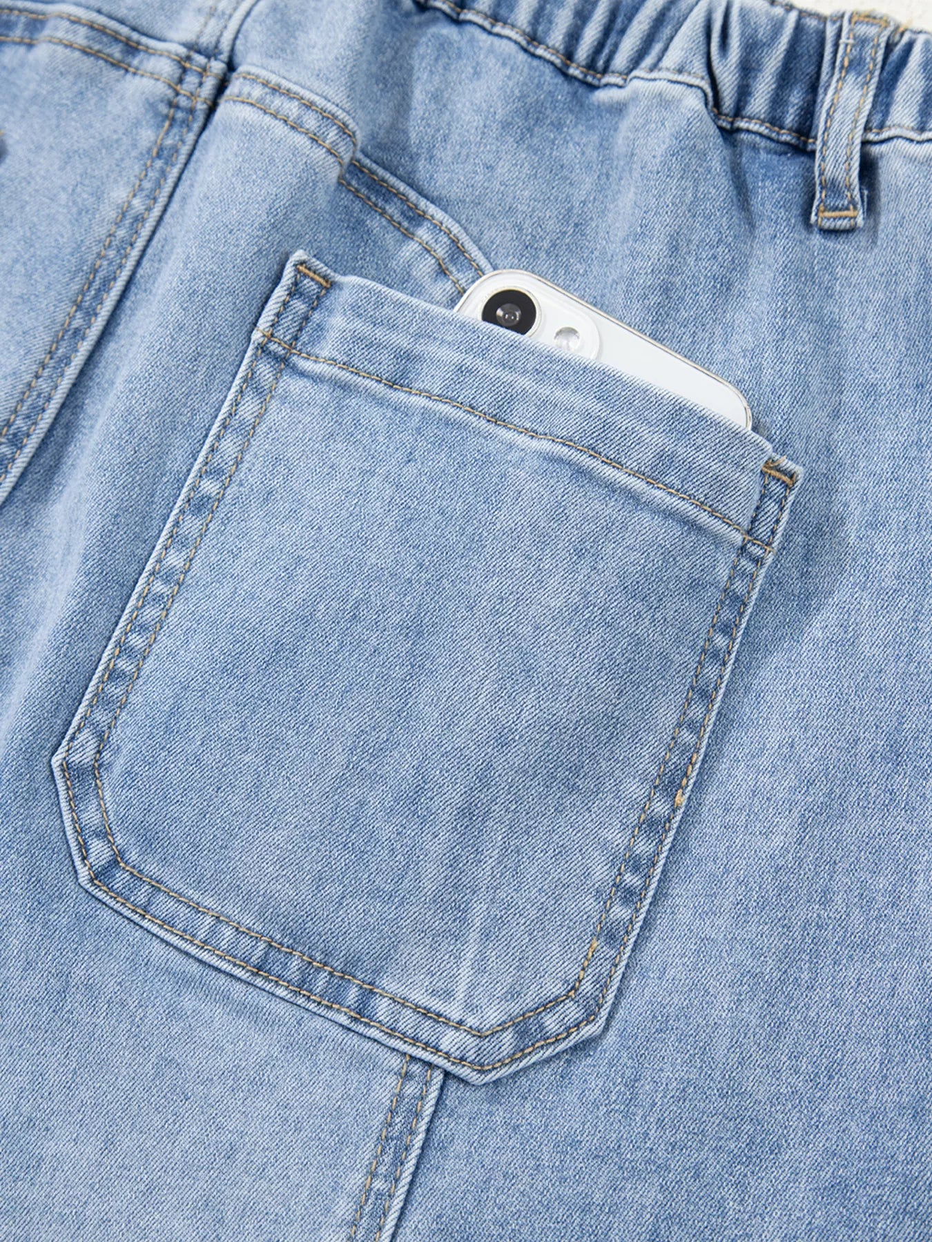 Light wash wide-leg drawstring jeans with raw hem and front pocket.
