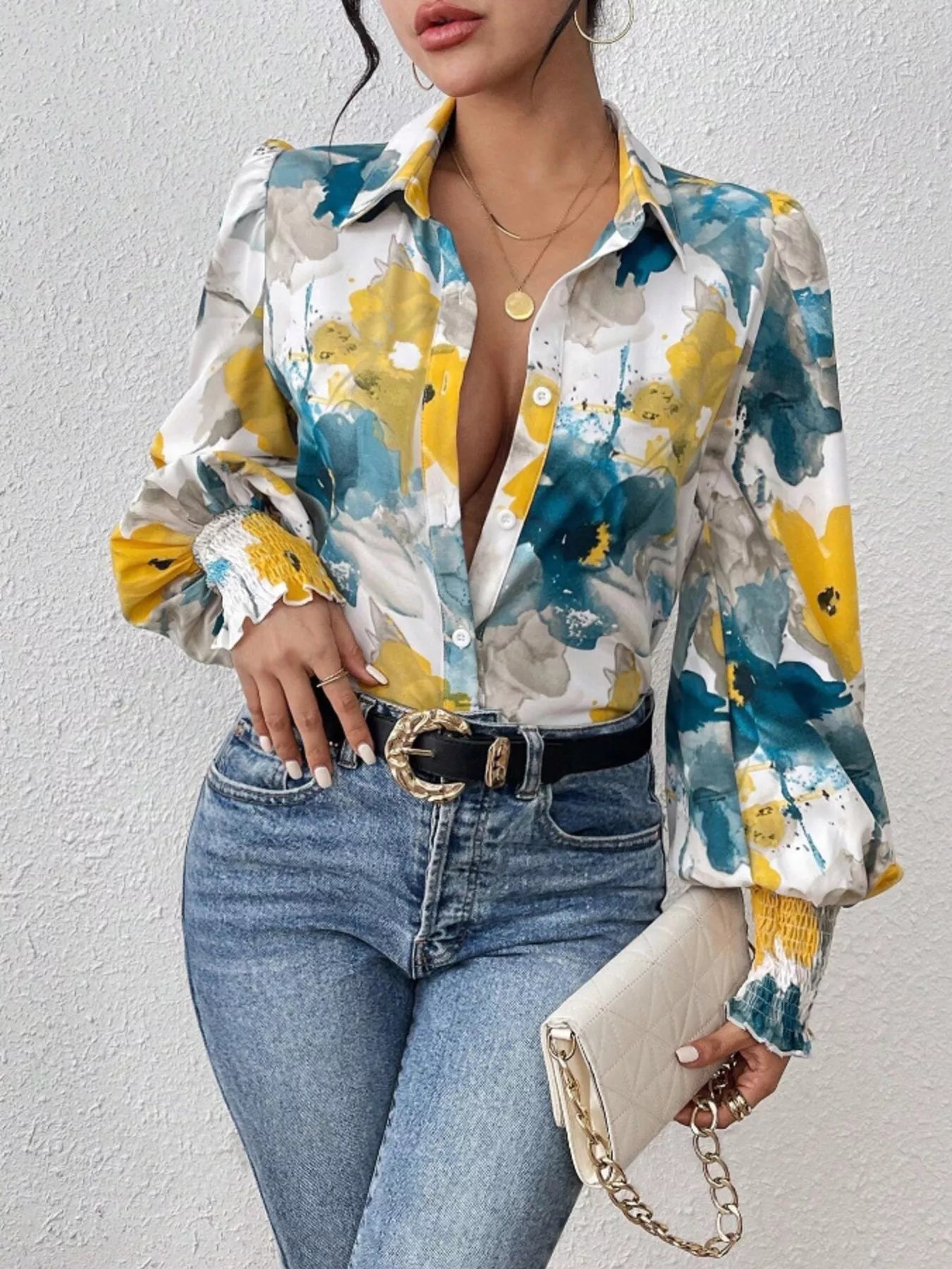 A printed button-up shirt with lantern sleeves made from a polyester blend.