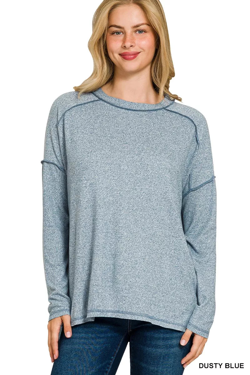 Dusty blue melange hacci hi-low tee with exposed seams on a model.