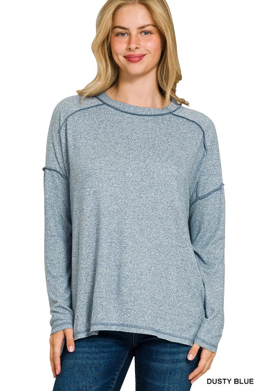 Dusty blue melange hacci hi-low tee with exposed seams on a model.