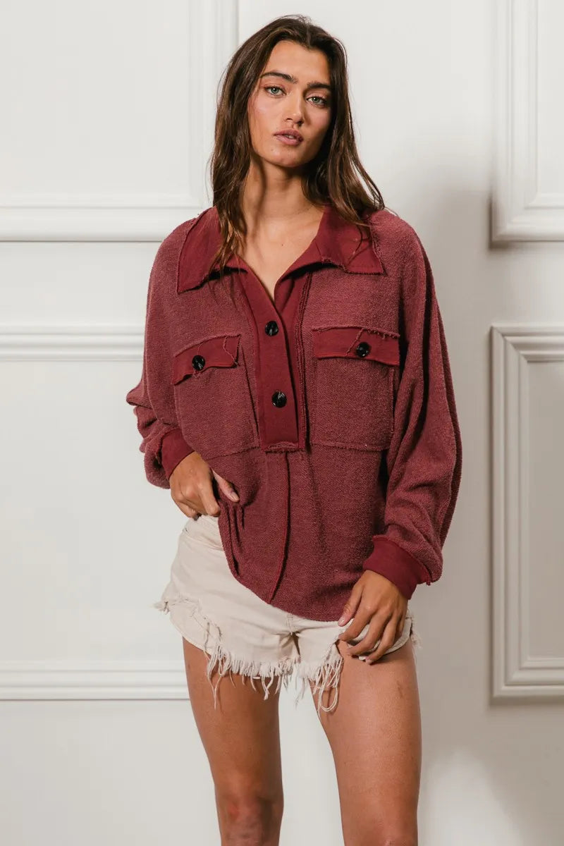Oversized maroon French terry collared top with buttons and pockets, modeled on a woman.